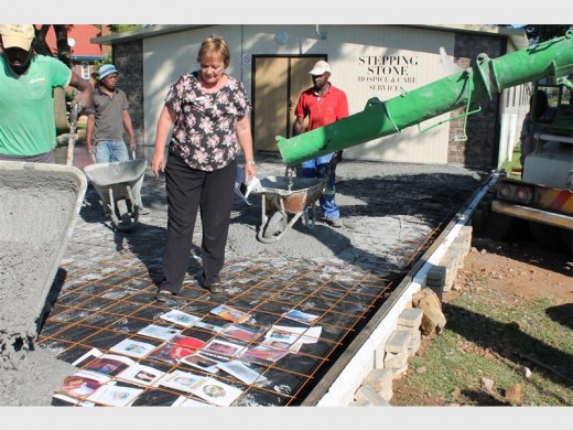 IN MEMORY OF: Stepping Stone Hospice and care service has previously been in the RECORD for good news, this picture looks back when CEO Tersia Burger looked on as cement is poured over photos of Stepping Stone Hospice patients who passed away over the last year. This was done in memory of those they have served. 