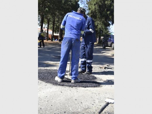 FILLING THE HOLES: Polyroads are fixing potholes in Coppel Street, Alrode South themselves. They are tired of waiting for the council to do it. The men in the photo are being trained by Polyroads.