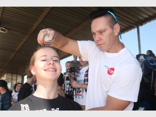 FOR CHARITY: Peter McGonigle sprays Danielle Colyn (13) from Laerskool Randhart's hair green.