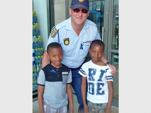 SAFEGUARDING COMMUNITIES: Warrant Officer André de Jager, spokesperson for the Germiston Police Station, with children present at the procession.