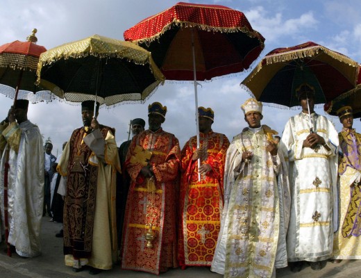 ETHIOPIAN ORTHODOX PRIESTS STAND UNDER THEIR UMBRELLAS IN ADDIS ABABA